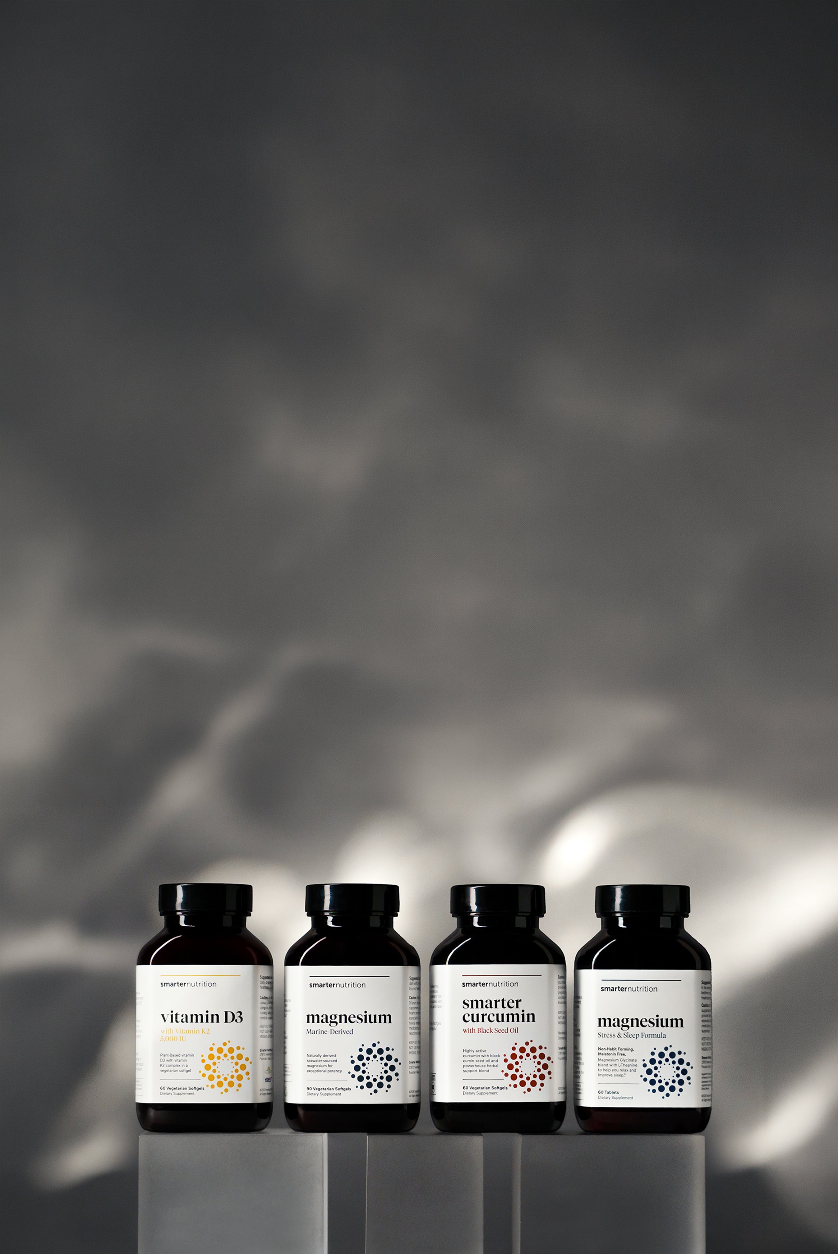 Smarter Nutrition supplement bottles on a reflective surface with a dark, textured background