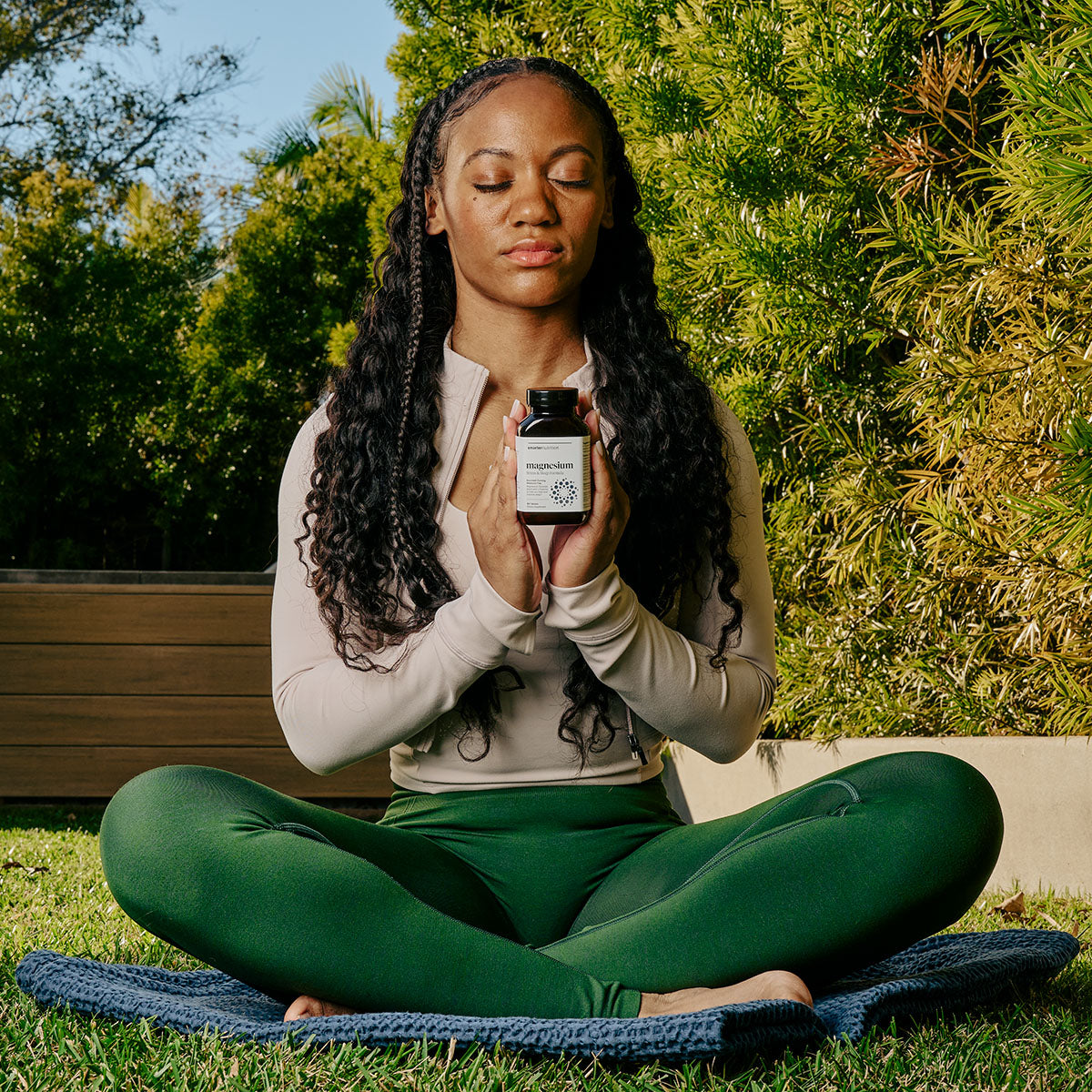 Girl doing yoga with a Smart Magnesium bottle in her hands.