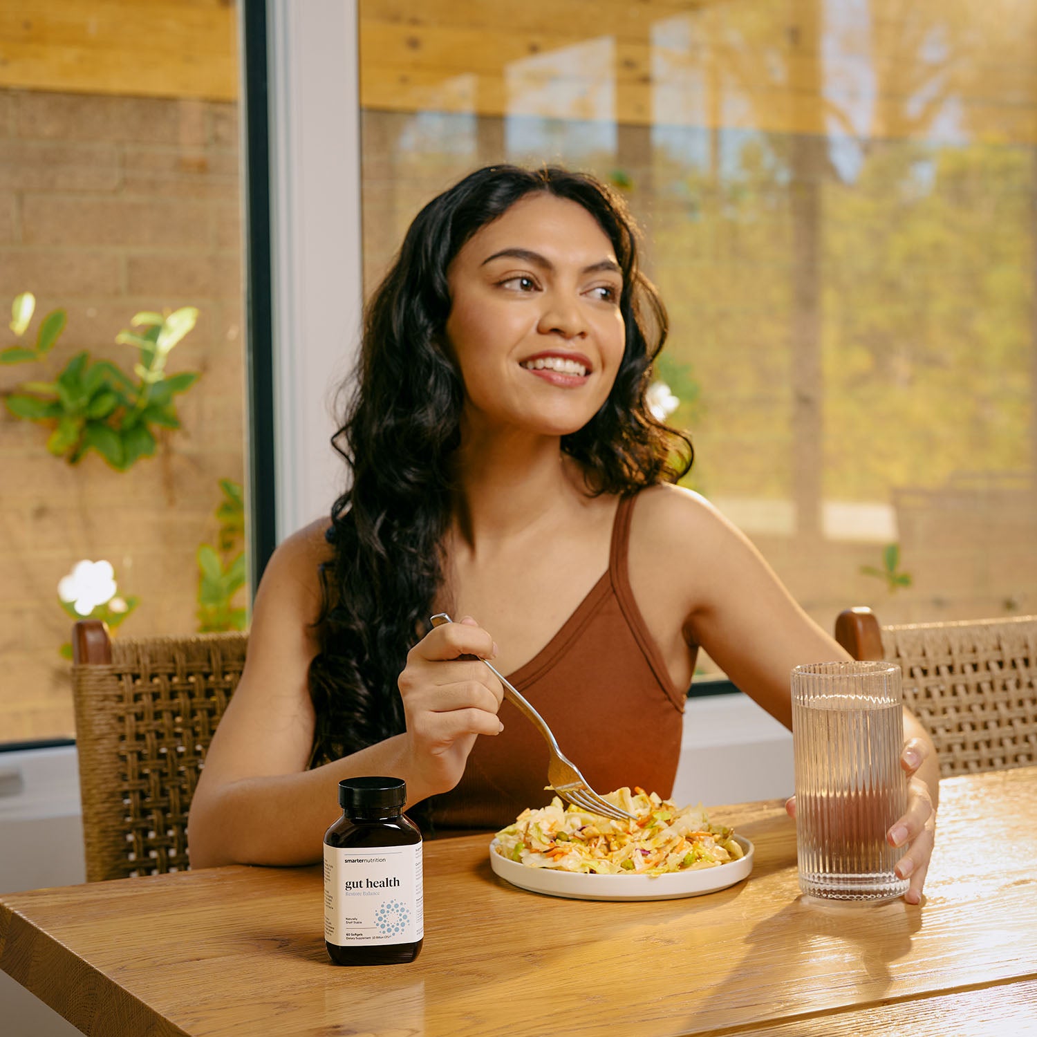 Girl eating salad with Smarter Gut health next to it