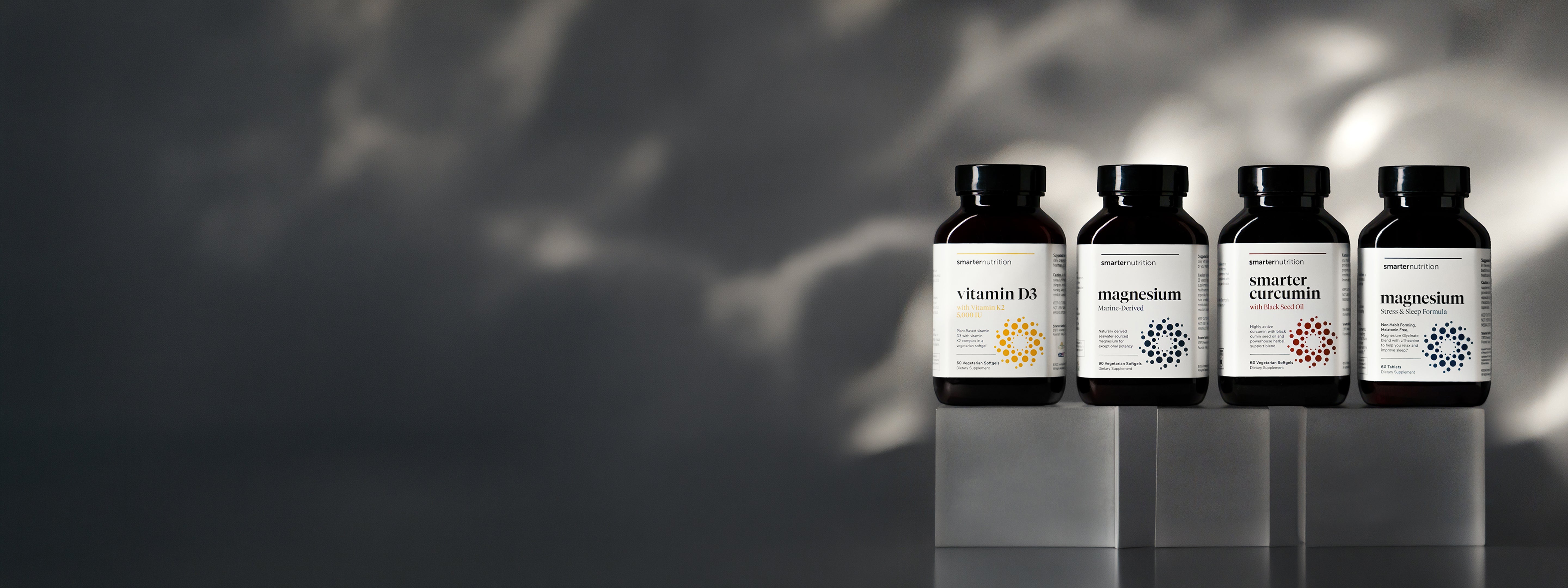 Five Smarter Nutrition Supplement bottles with on a dark gray background